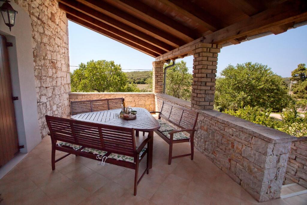 MugebaHoliday Home Stancija Becic的庭院设有两把椅子和一张石墙桌子。