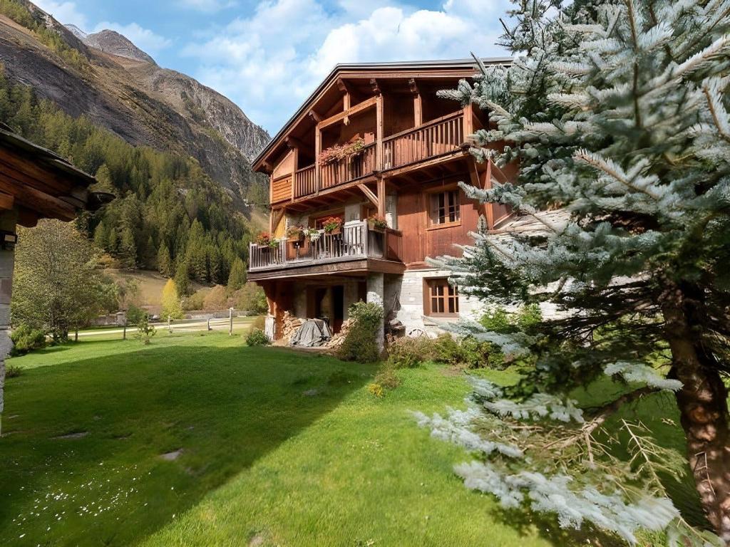 蒂涅CASA-Chalet Brizolée lake-view chalet in Tignes close to ski area的一座大型建筑,在草地上设有阳台