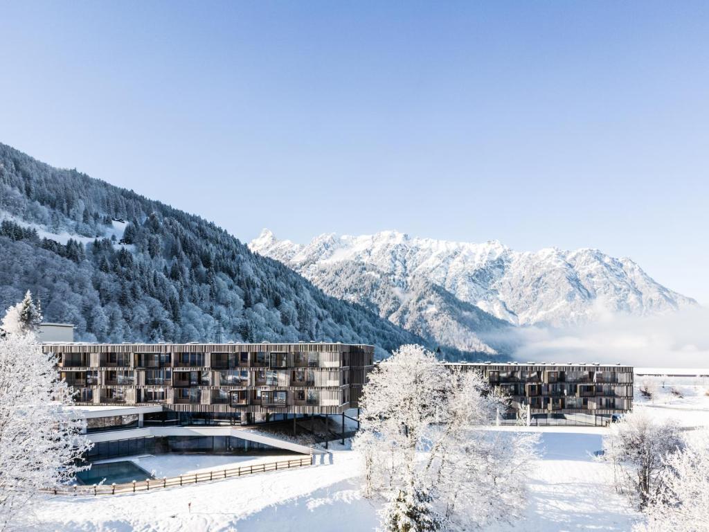 施伦斯Falkensteiner Family Hotel Montafon - The Leading Hotels of the World的山底下雪中的酒店