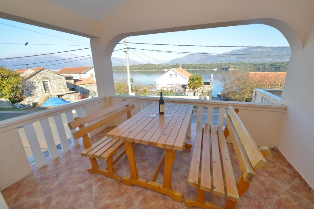 蒂瓦特Apartments and Studios Jokić的阳台上的野餐桌,提供一瓶葡萄酒
