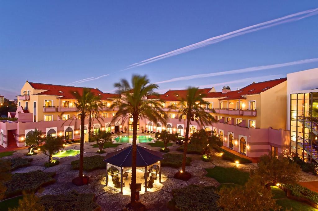 辛特拉辛特拉佩斯塔纳高尔夫SPA度假酒店的一个带凉亭和棕榈树的庭院的酒店