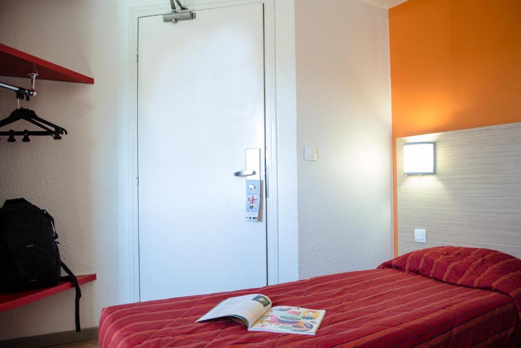加来HECO Calais Centre-Gare的一间卧室配有红色的床,上面有一本书