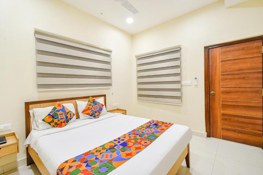 海得拉巴FabHotel Prime AM Suites - Nr Secunderabad Railway Satation的一间卧室配有一张床和一扇木门