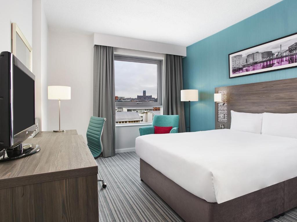 利物浦Leonardo Hotel Liverpool的一间设有大床和窗户的酒店客房