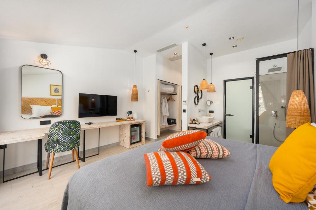厄吕代尼兹Ölüdeniz Blu Luxury Unique Hotel - Adults-Only的有一张床、一张书桌和一台电视的房间