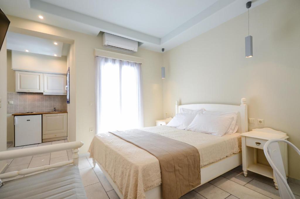 纳克索乔拉瓦西利科斯公寓式酒店的一间白色卧室,配有床和厨房