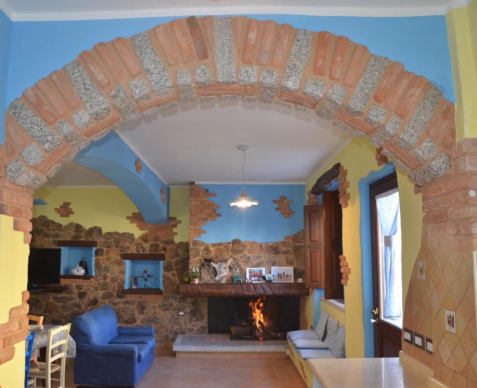 丰尼B&B La Dolce Sosta的客厅的拱门,设有石制壁炉