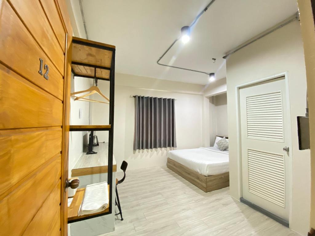 素叻ซับรูมโฮเทล Subroom Hotel的一间设有床铺的房间和通往卧室的门