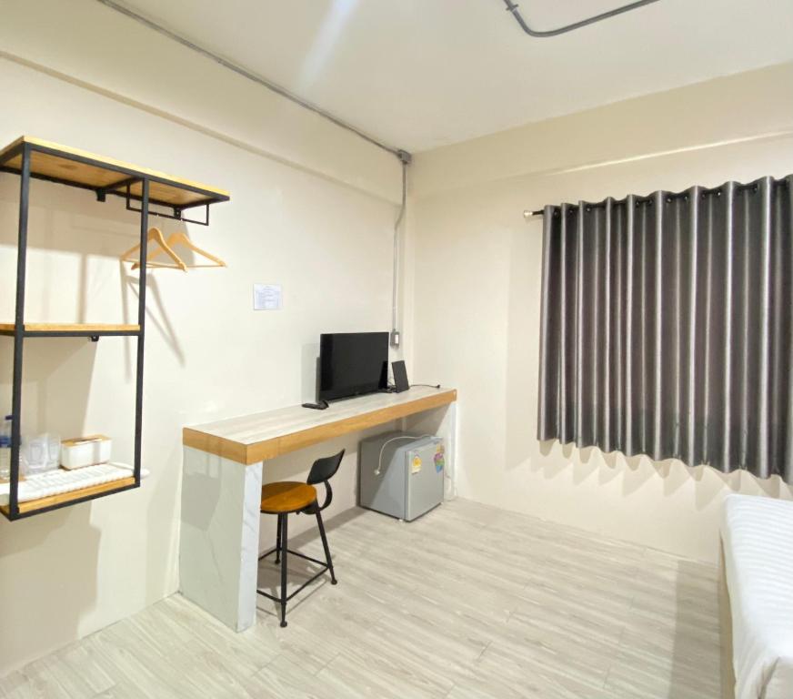 素叻ซับรูมโฮเทล Subroom Hotel的一间带书桌、电脑和床的房间