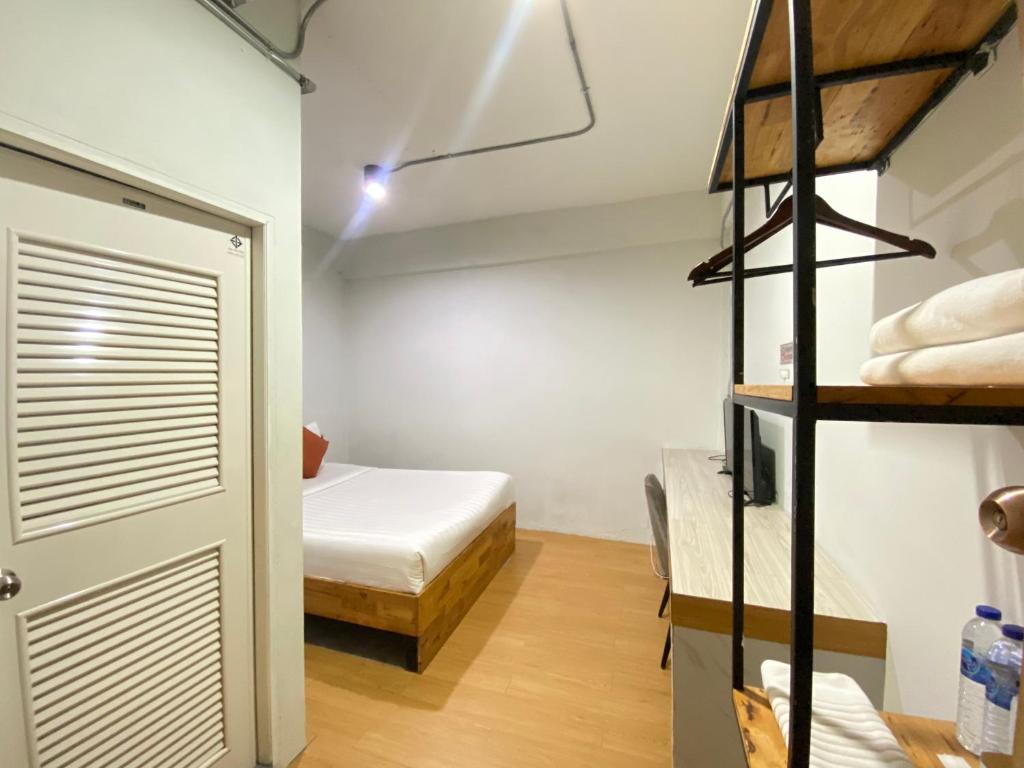 素叻ซับรูมโฮเทล Subroom Hotel的带一张床的房间和带衣柜的房间