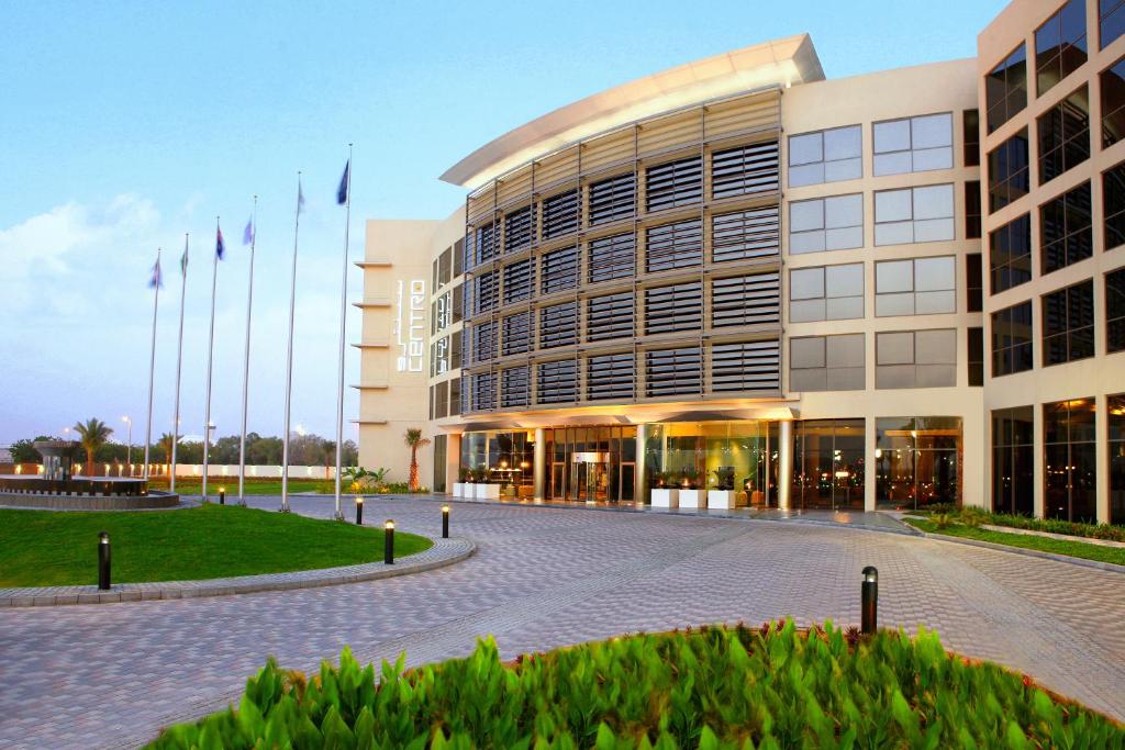 沙迦Centro Sharjah的前面有旗帜的大建筑