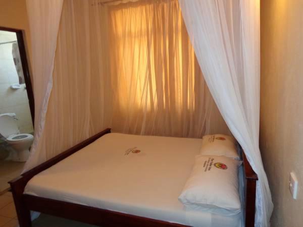 蒙巴萨福尔克斯旅馆的床上床,带窗帘的房间