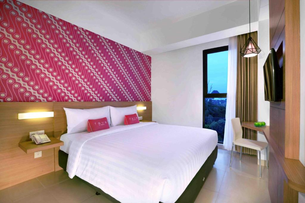 日惹日惹马里奥波罗酒店的一间卧室设有一张红色墙壁的大床