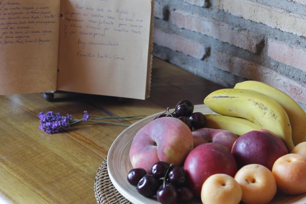 艾利翁La Caseja de Ayllón的书旁边的桌子上放上一盘水果