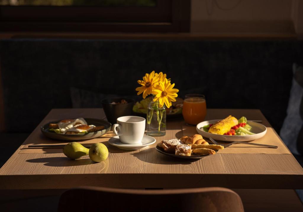 梅加克瑞奥Evora Luxury Suites的一张带早餐食品和花瓶的桌子