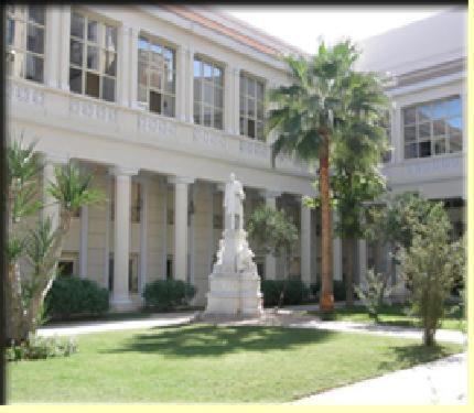 亚历山大Alexander The Great Hotel的一座棕榈树建筑前的雕像
