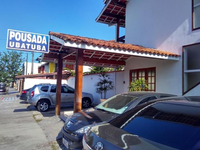 乌巴图巴Pousada Ubatuba Itaguá的酒店门前设有停车场,可停放汽车