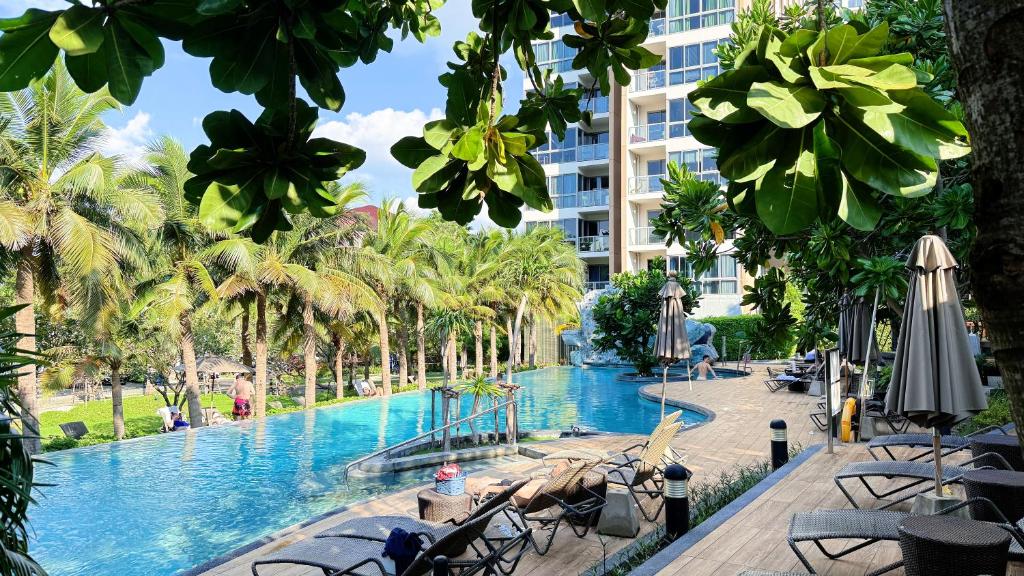 南芭堤雅unixx seaview hotel的棕榈树度假村的游泳池