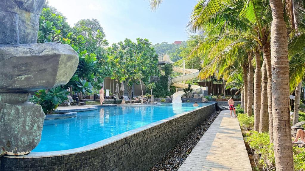 南芭堤雅unixx seaview hotel的棕榈树度假村的游泳池