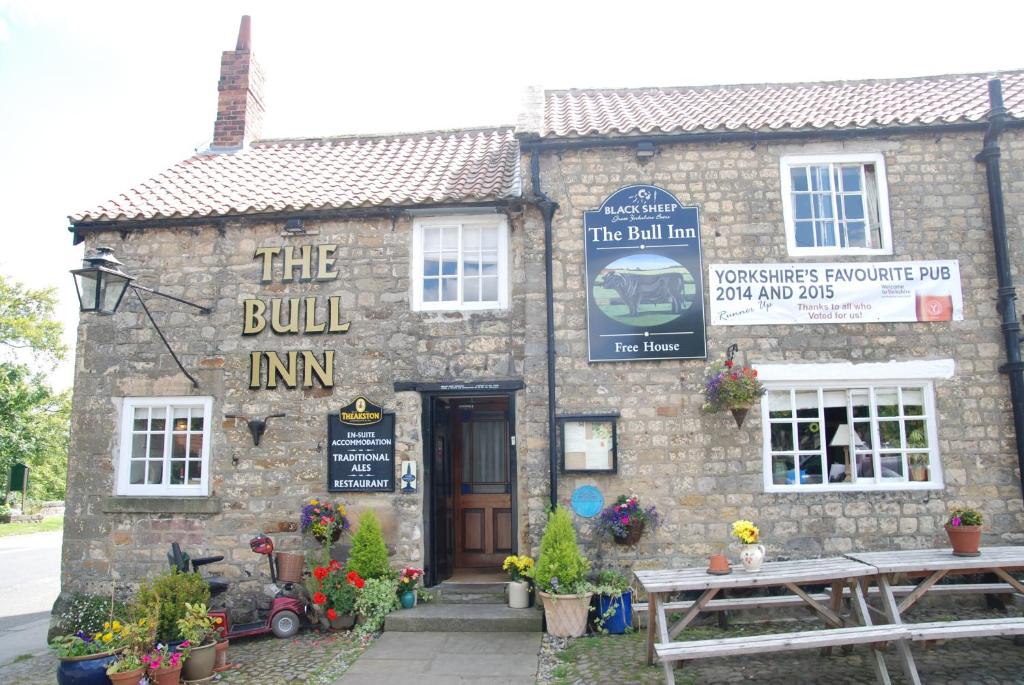 里彭The Bull Inn West Tanfield的一座建筑,上面有读建筑旅馆标志