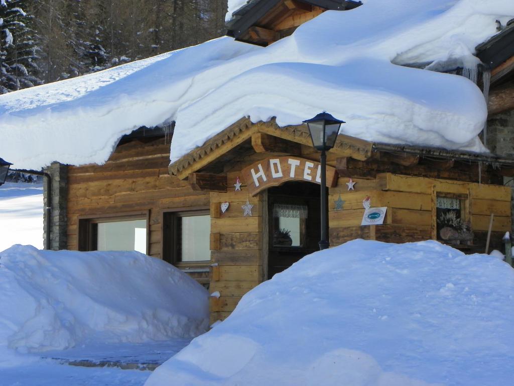 拉特乌伊莱莱斯格兰格斯酒店的小木屋被雪覆盖,上面有标志