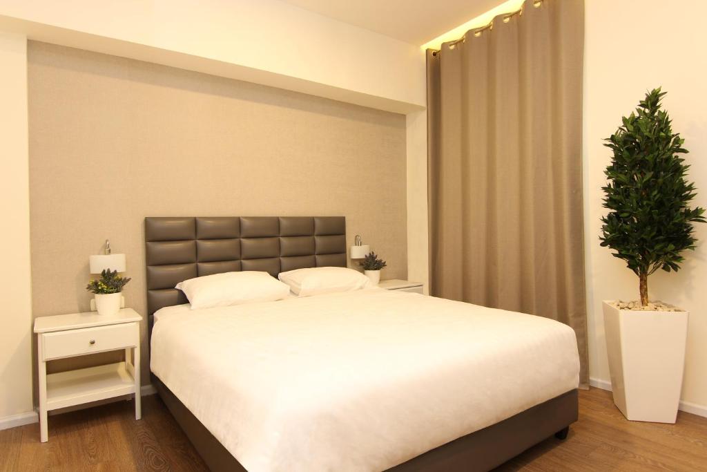 特拉维夫艾德尔森酒店 的一间卧室配有一张大床和盆栽植物