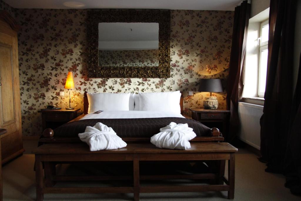尼德根Zur Ewigen Lampe Romantisches Landhotel & Restaurant的一间卧室配有一张带毛巾的桌子。