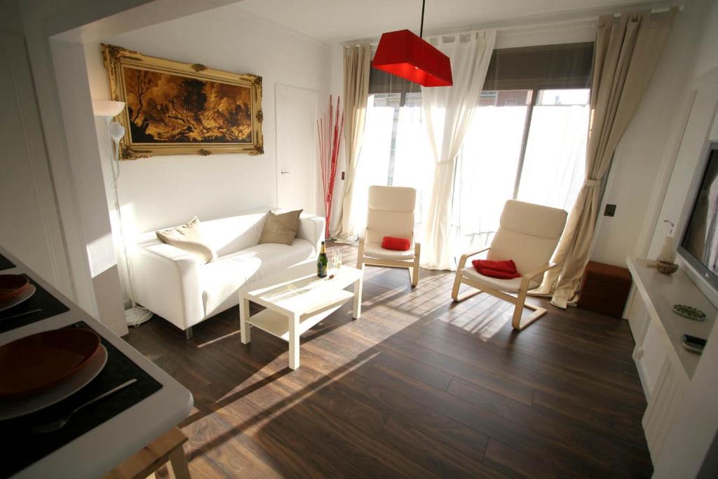 巴塞罗那克洛特区及圣家堂附近公寓的客厅配有白色沙发和两把椅子