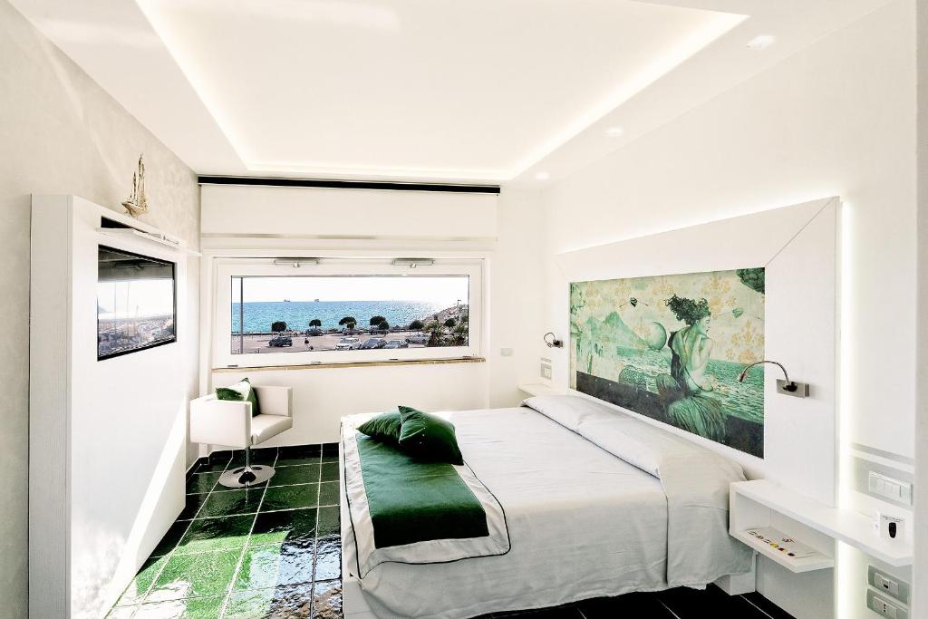 萨莱诺拉玛德格拉喜素旅馆的白色的卧室设有一张大床和一个窗户
