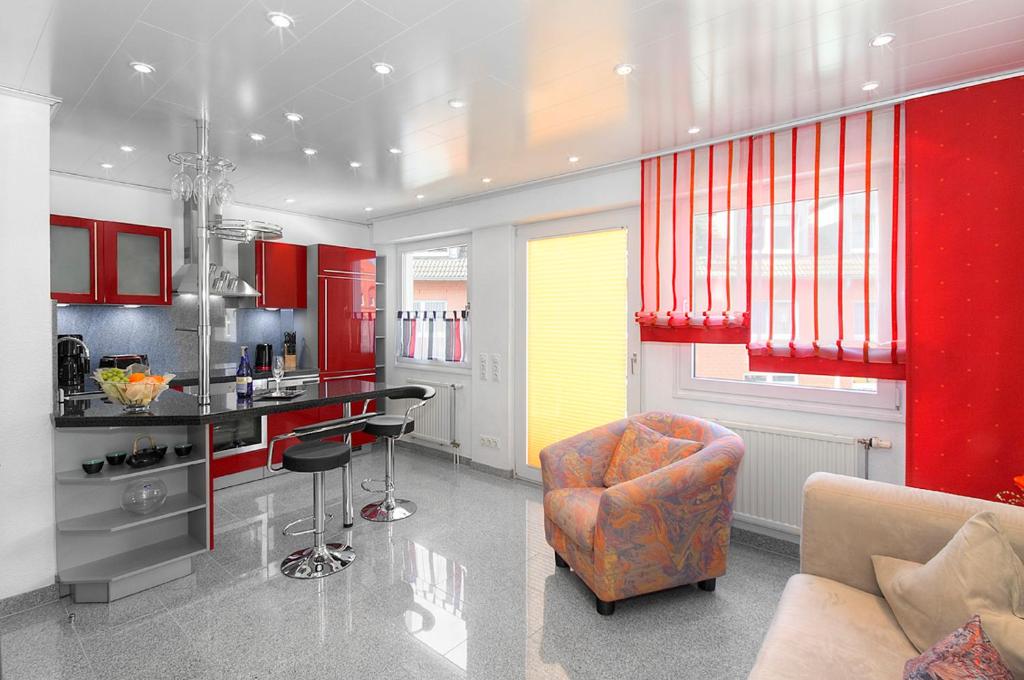 多特蒙德多特蒙德DW16~17~19公寓的厨房配有红色橱柜、沙发和椅子