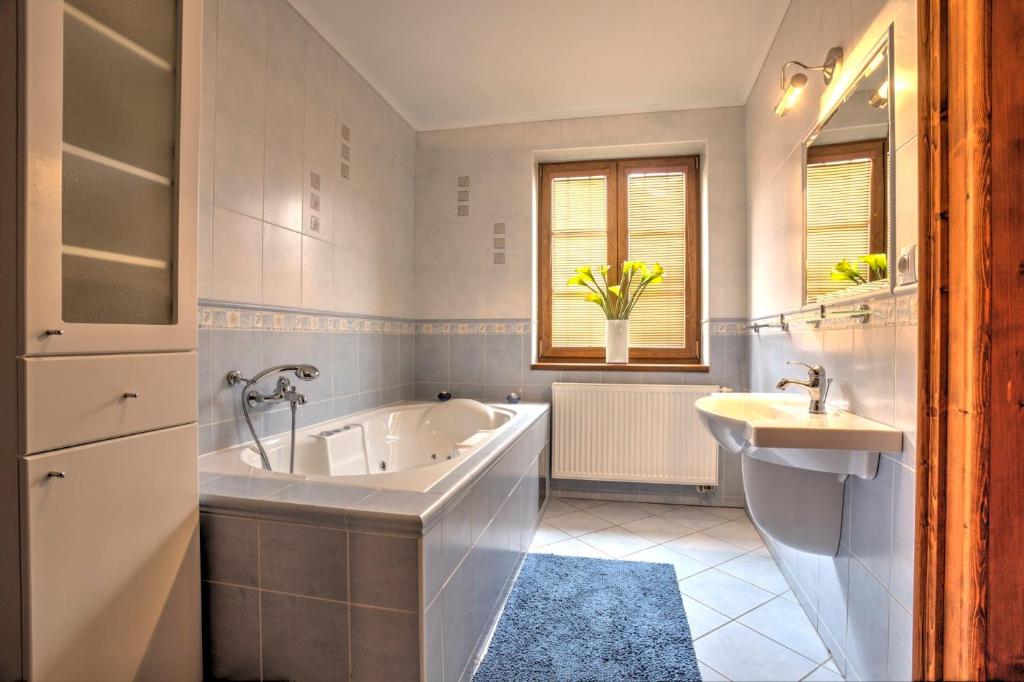 Slovenský GrobPenzión Grobský Dvor的白色的浴室设有浴缸和水槽。