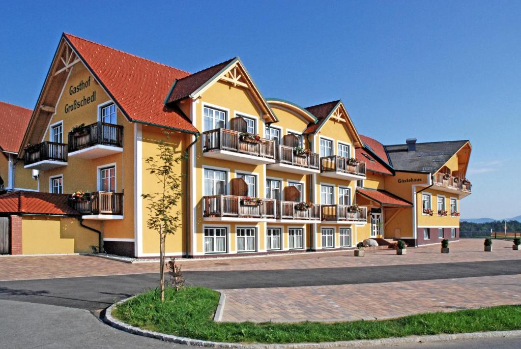 拉斯尼茨霍格鲁切尔克拉梅沃特酒店的一座大型黄色建筑,位于街道上,设有阳台