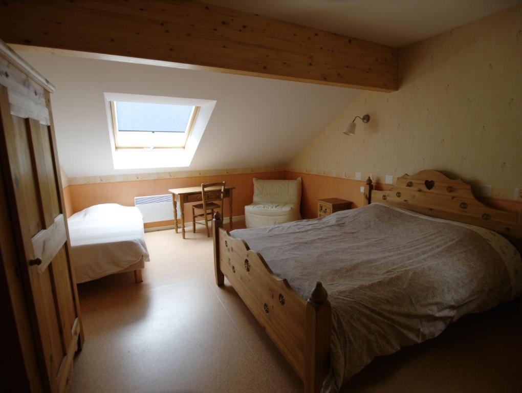 Taintrux拉切里奥勒旅舍的一间卧室设有两张床、一张桌子和一个窗口
