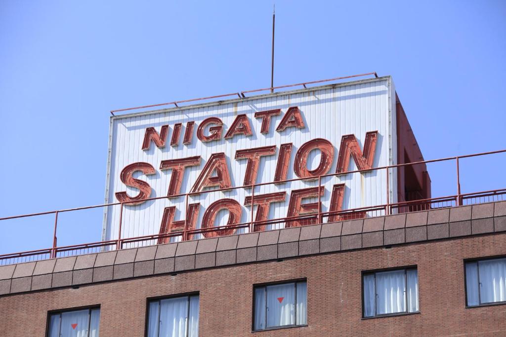 新泻新泻站酒店的建筑物顶部的旧 ⁇ 虹灯标志