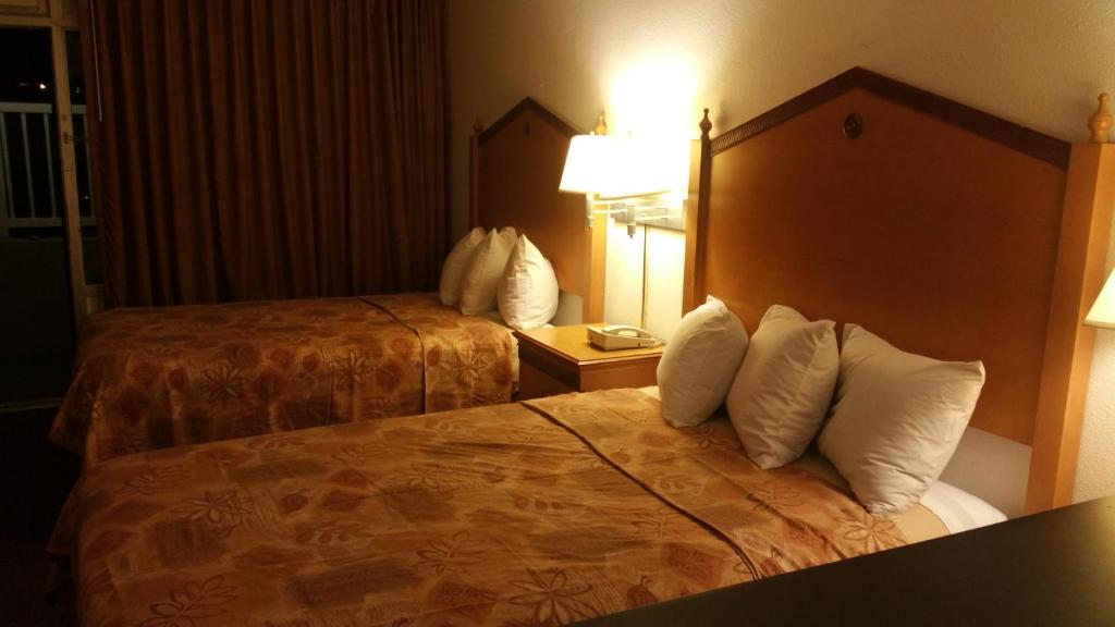 温泉城Lotus by Hotel Inn - Hot Springs的酒店的客房 - 带2张带白色枕头的床