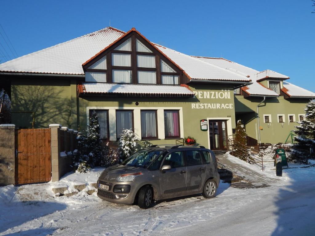 布尔迪山下慕尼雪克尤卡斯尼切膳食公寓酒店的雪中停在房子前面的汽车