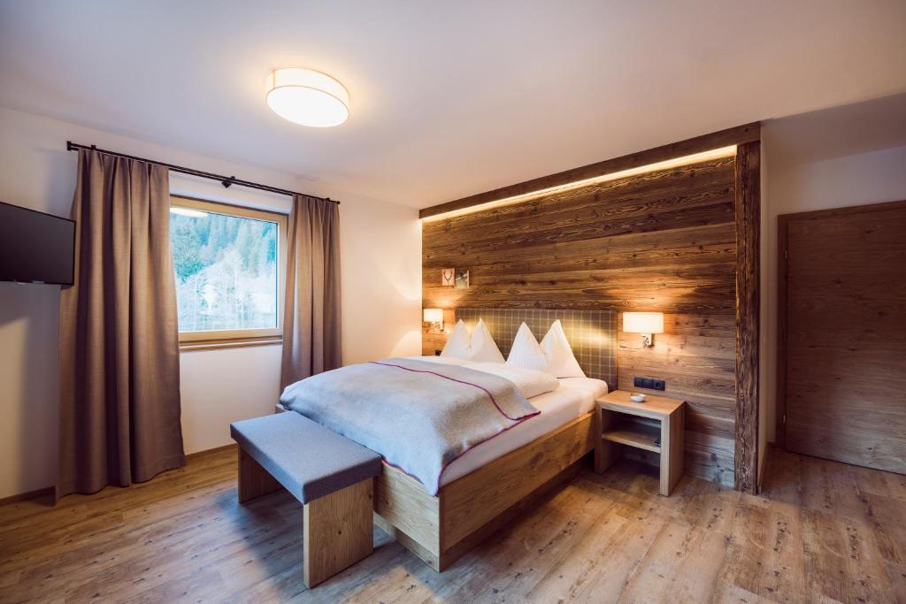 施图拜河谷新施蒂夫特stoanmandl Wohlfühlappartements的一间卧室设有一张带木墙的大床
