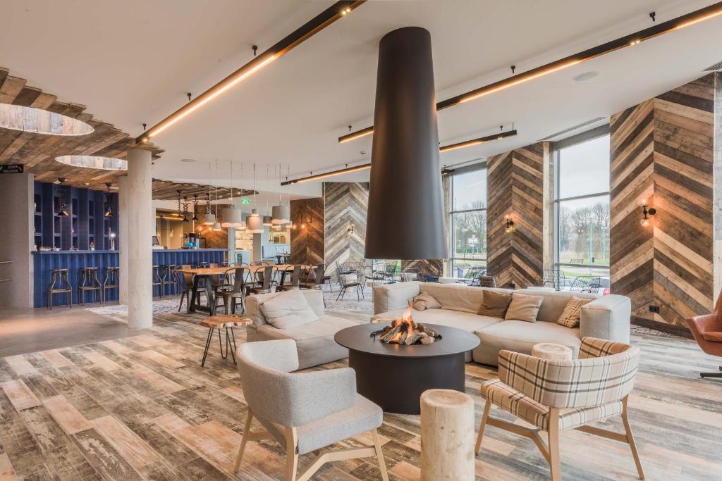 阿姆斯特丹城市洛奇酒店的客厅配有沙发、椅子和壁炉
