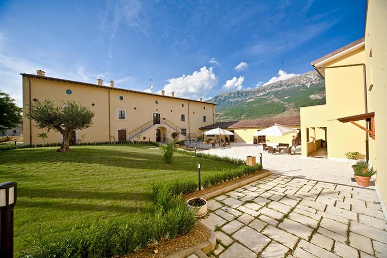 Pratola Peligna宫欧娜别墅酒店的一座带草地庭院和庭院的大型建筑