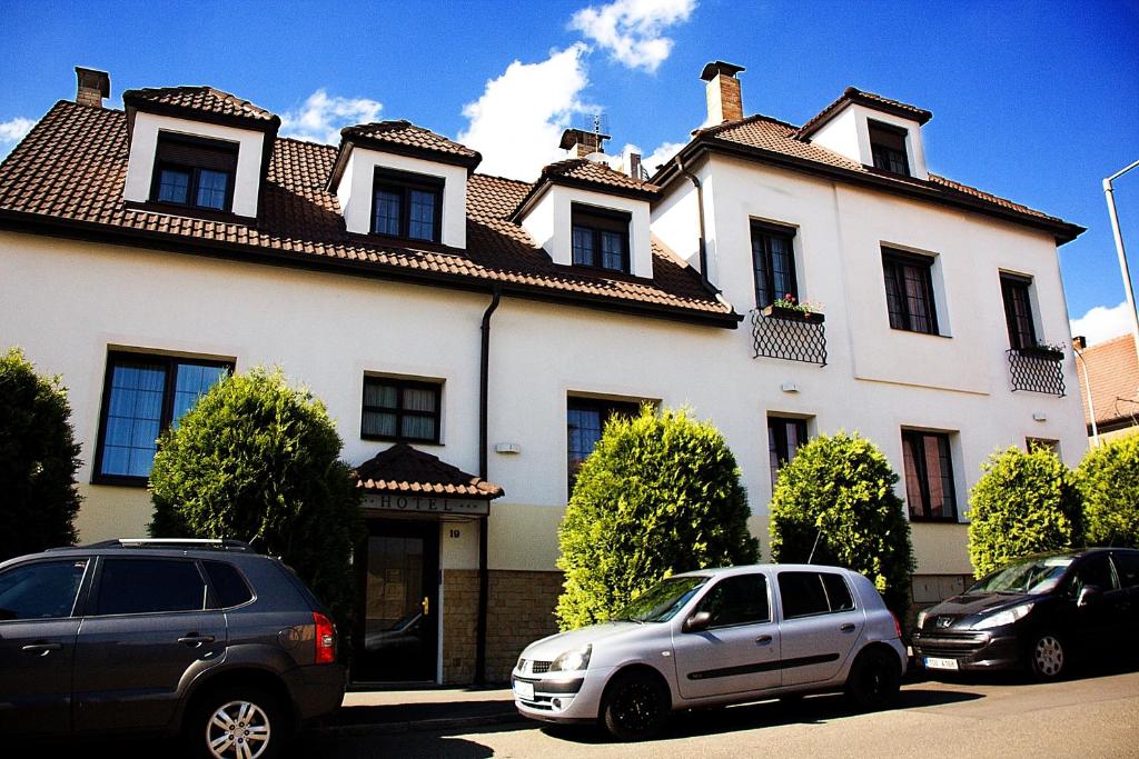 布拉格优越酒店的两辆汽车停在一个白色的大房子前面