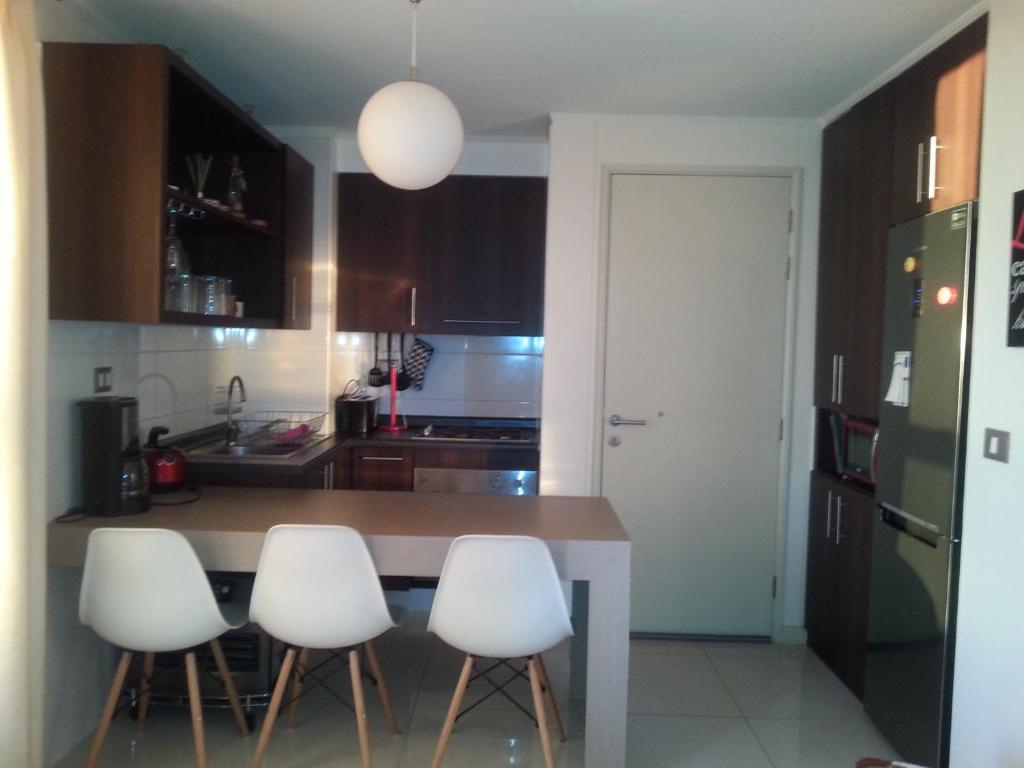特木科Apartamento Alemania的厨房配有桌子和四把白色椅子