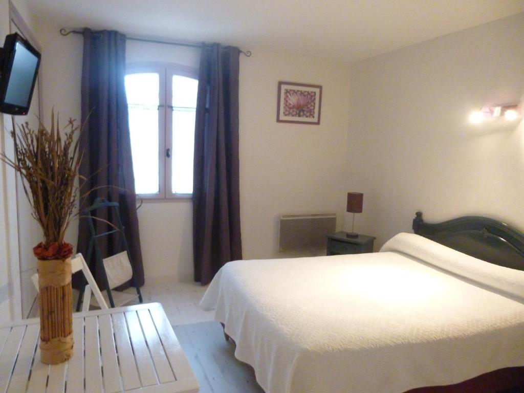弗尔东河畔维农圆桌宾馆的一间卧室设有一张床、一个窗口和一台电视