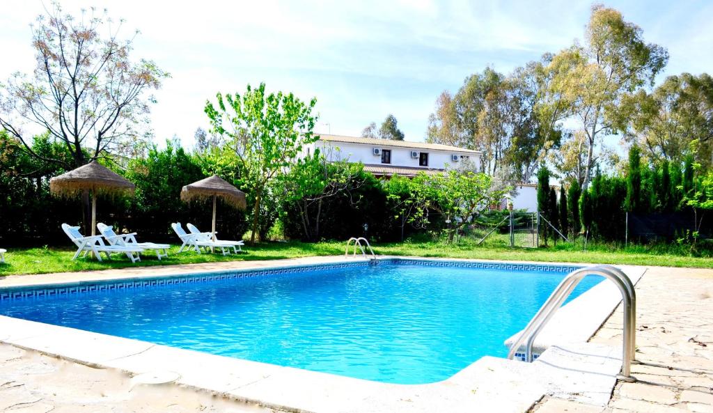 维拉努埃瓦·德·塔皮亚路拉尔拉帕罗马酒店的一个带两把椅子的游泳池以及一座房子