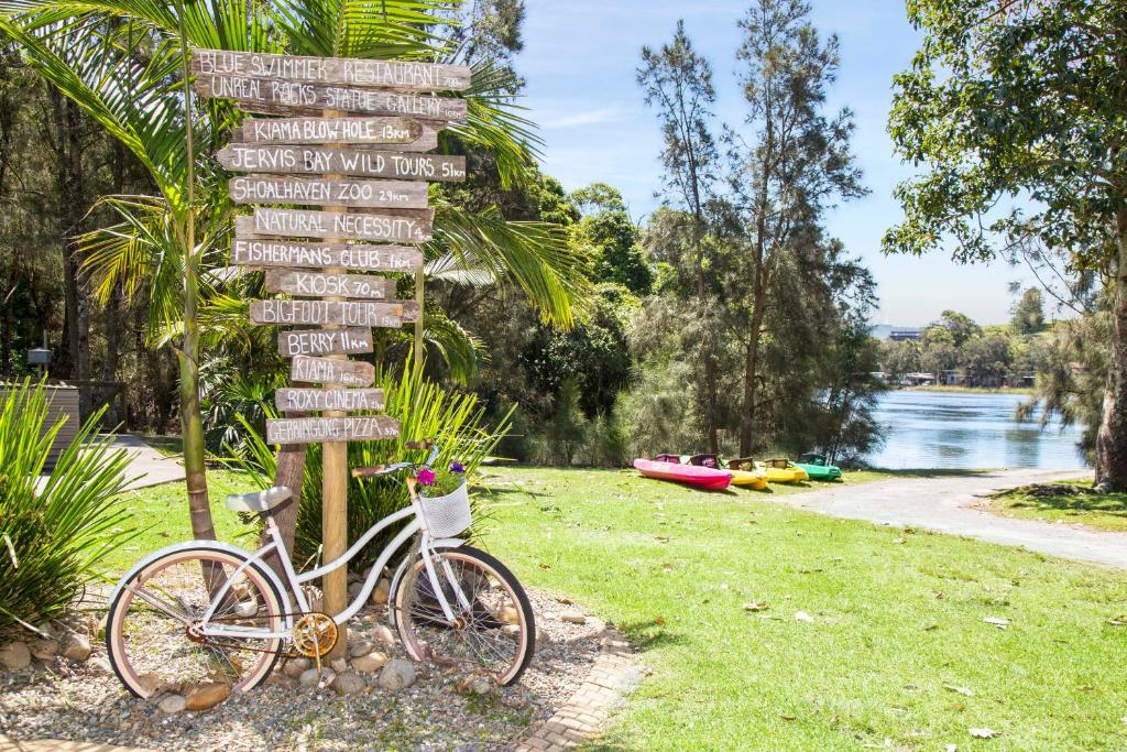 格罗拉七英里海滩假日公园酒店的停在标牌旁的自行车
