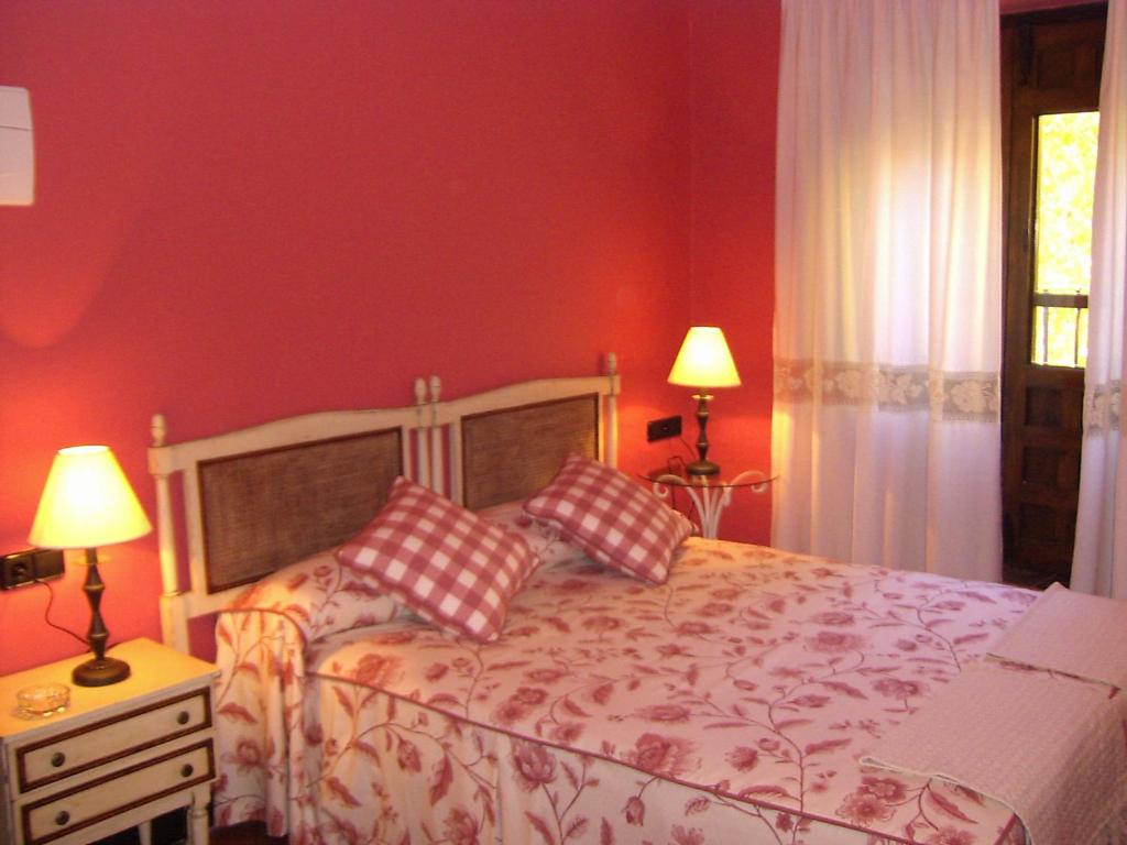 圣埃斯特万德尔瓦勒方块磨坊旅馆的一间卧室设有红色的墙壁和一张带两个枕头的床
