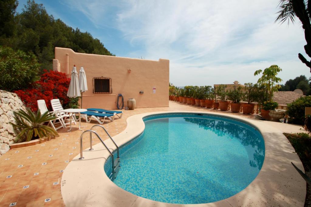 莫莱拉Chrisuli - well furnished villa with panoramic views in Moraira的一个带庭院和房子的游泳池