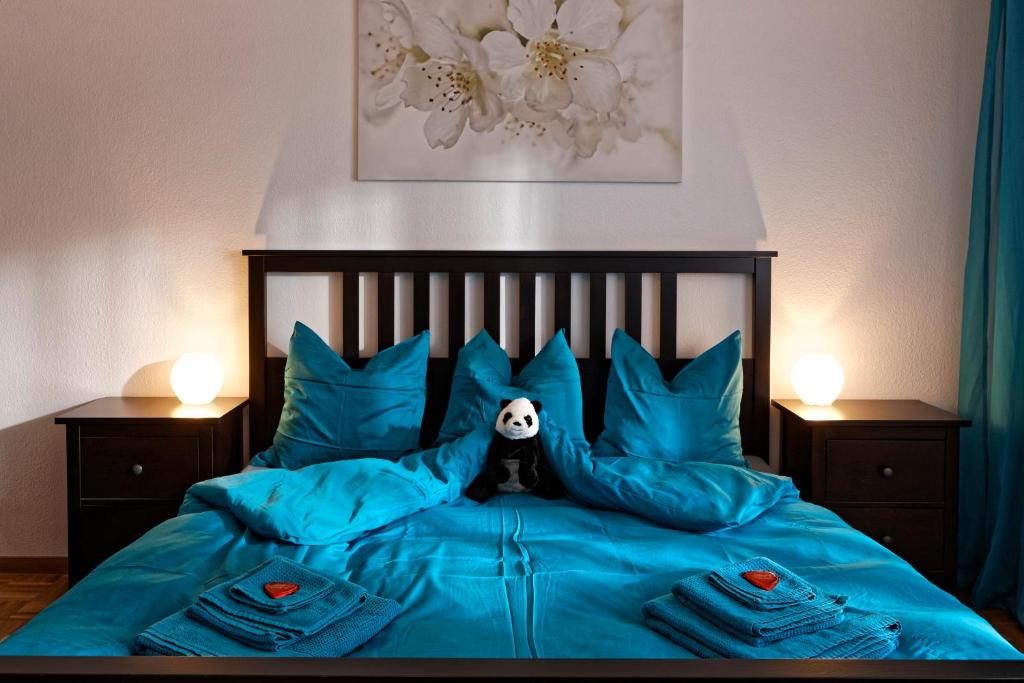 伯尔尼麦克斯航空别墅&公寓旅馆的一间卧室配有一张带蓝色枕头和熊猫的床。