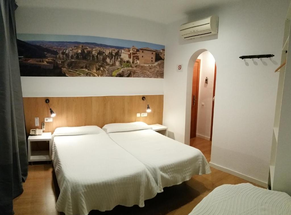 科尔内拉德罗布雷加特科尔内雅旅馆及餐厅的一间卧室设有两张床,墙上挂着一幅画