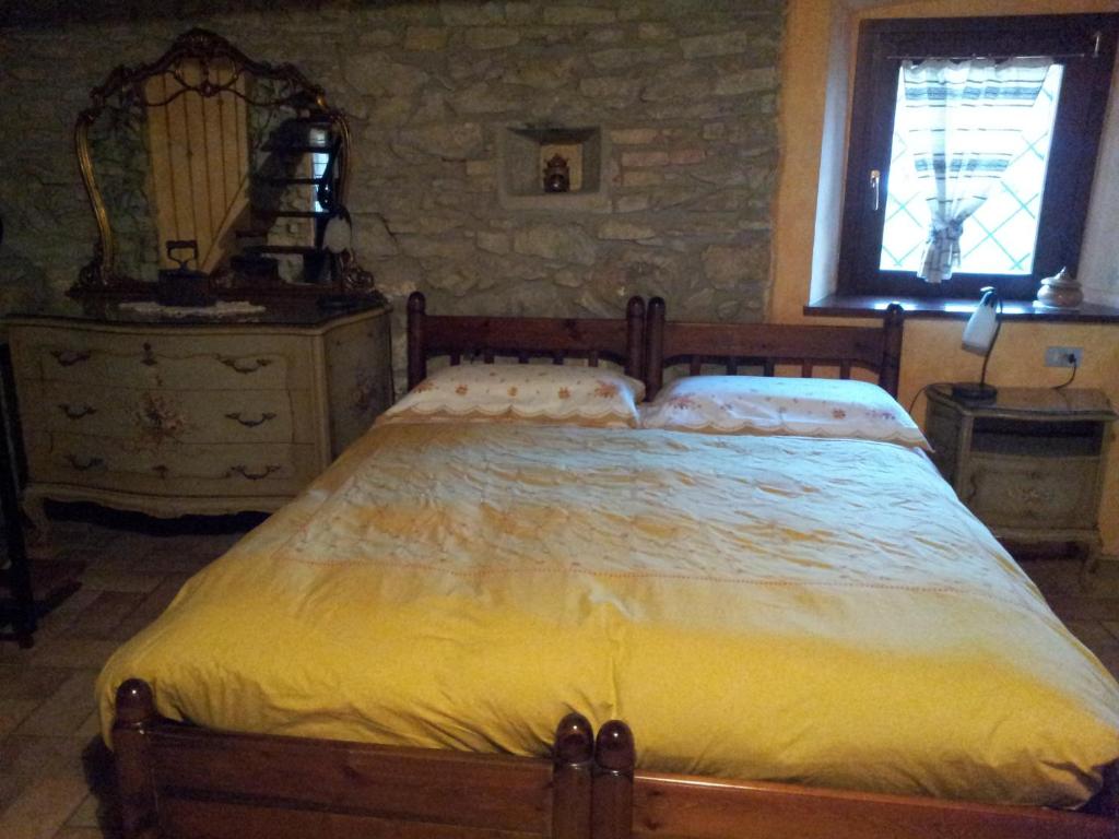 Palazzago卡希纳朗奇农家乐的一间卧室设有一张大床和石墙