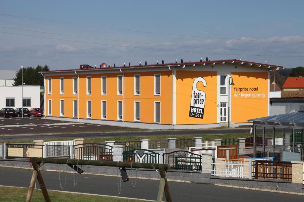 巴德瓦尔特斯多夫平价酒店的黄色的建筑,旁边标有标志